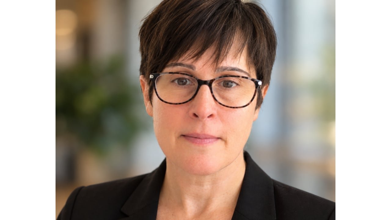 default-863 A woman wearing glasses and short dark hair smiles at the camera.